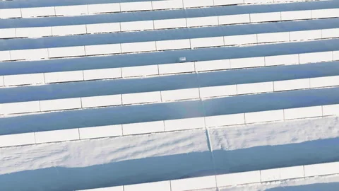 High angle drone shot circling over snowy solar panels, sunny winter morning Stock Footage 325953026