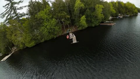 High angle drone shot looking down at a wooden lake dock with people fishing Fotos de archivo