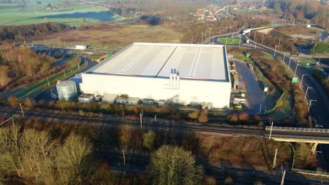 High-angle drone shot showing the connection between industrial warehousing and Stock Footage 333937826