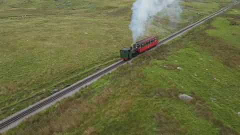 A high angle drone shot of a steam train in the mountains. Stock Footage 253677122