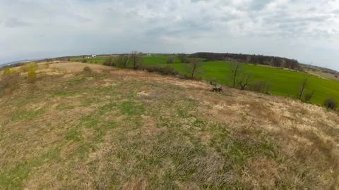 High angle drone view of a distant tractor working a wide field Foto stock