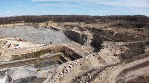 High-angle drone view of an expansive pit site featuring layered stone, dirt Stock Footage 306048527