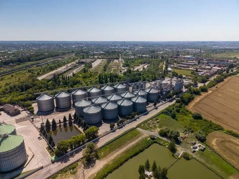 High Angle Drone View of Extensive Metal Grain Silo Infrastructure and Ponds Stock Photos