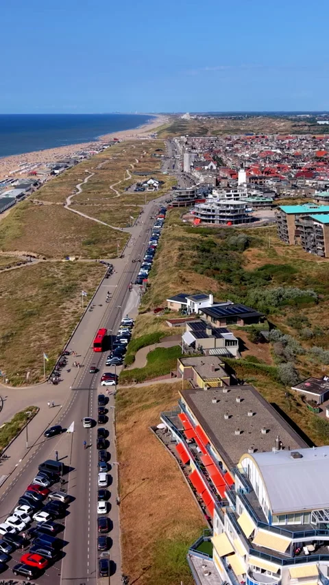 High-angle drone view of Katwijk aan Zee coastal road with red bus, parking Stock Footage 347127991