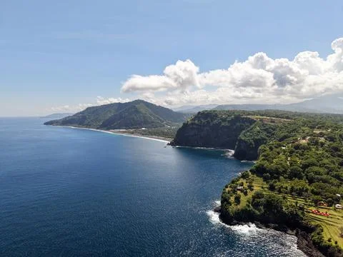 High Angle Drone View of Lush Tropical Cliffs and Deep Blue Ocean Coastline Stock Photos
