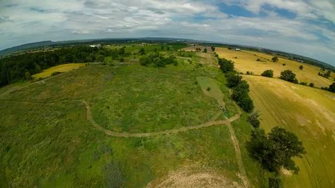 High angle drone view of a moving tractor beside a food plot Stock Photos