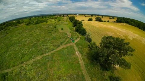 High angle drone view of a moving tractor beside a food plot Stock-Fotos