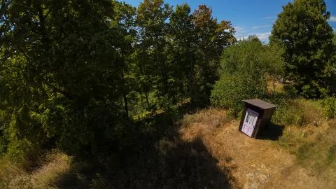 High angle drone view of a rustic wooden outhouse shed near forest trees Foto stock