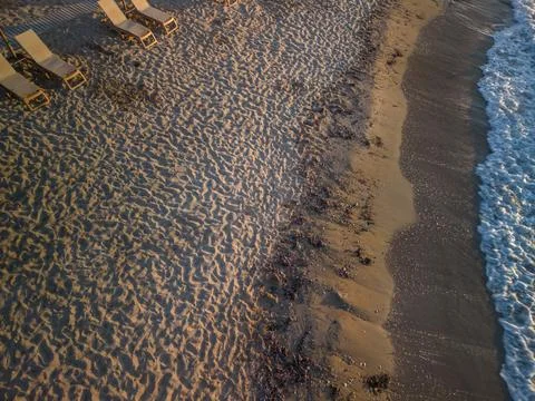 High Angle Drone View of Sandy Beach with Sunbeds at Sunset Stock Photos