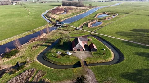 High-angle drone view of a straight Dutch canal cutting through vibrant green Stockbeeldmateriaal 330283208