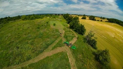High angle drone view of a tractor and an ATV beside a field Foto stock