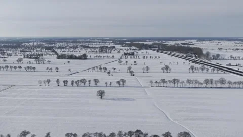 High-angle drone view of a vast, snowy landscape featuring rural roads Stock Footage 327602116