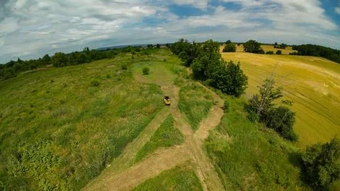 High angle drone view of a yellow ATV by a food plot and farm fields Stock Photos