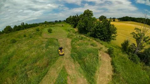 High angle drone view of a yellow ATV by a food plot and farm fields Stock Photos