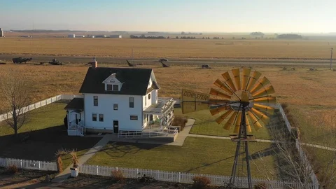 A high angle establishing shot of a classic farmhouse farm and barns in rural Stock Footage 107437385