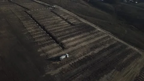 High angle footage of a field with trenches and poles, workers walking Stock Footage 160115617