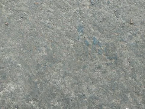 A high-angle, full-frame shot of a weathered concrete or cement surface. Th.. Photos
