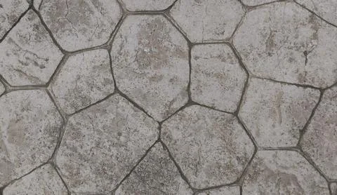 High-angle full-frame shot of a weathered gray stamped concrete floor. Stock Photos
