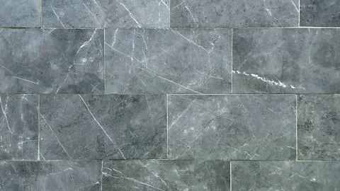High-angle full-frame view of a modern grey marble tiled wall background. Stock Photos