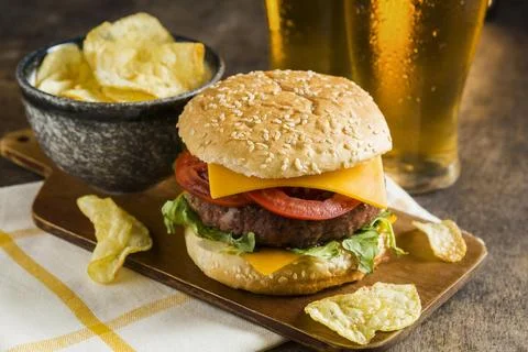 High angle glasses beer with cheeseburger potato chips Stock Photos