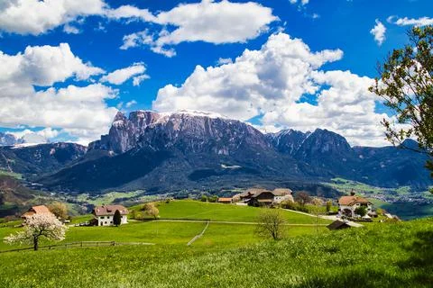 High angle of green fields with several tiny buildings with the background of Stock Photos