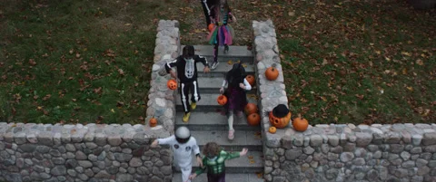 HIGH ANGLE Group of trick-or-treating kids walking down the stairs Stock Footage 141589170