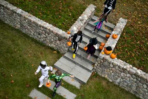HIGH ANGLE Group of trick-or-treating kids walking down the stairs Stock Photos