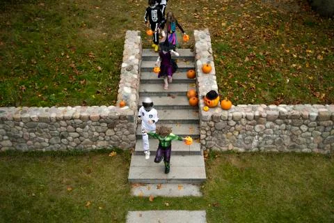 HIGH ANGLE Group of trick-or-treating kids walking down the stairs Stock Photos