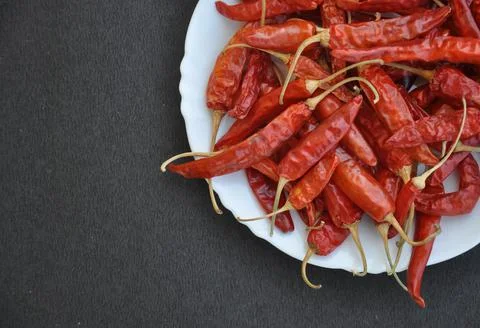 High angle of heap of red chilli peppers on the white plate  Stock Photos