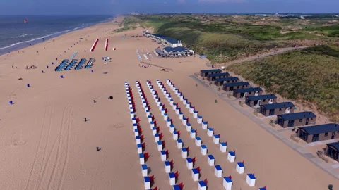 High angle horizontal aerial drone video clip of beach cabins, wooden chale Stock Footage 342698434