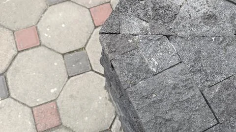 High angle horizontal shot shows a dark grey volcanic stone pillar beside p.. Stock Photos