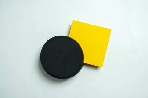 A high-angle, minimalist flat lay photo featuring a black circular object a.. Stock Photos