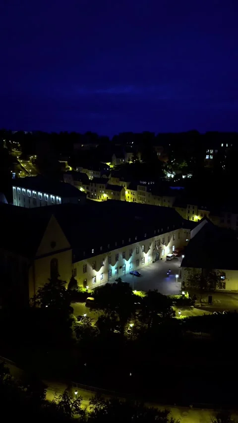 High-angle night view of an old European town featuring glowing streetlights 스톡 동영상 346046219
