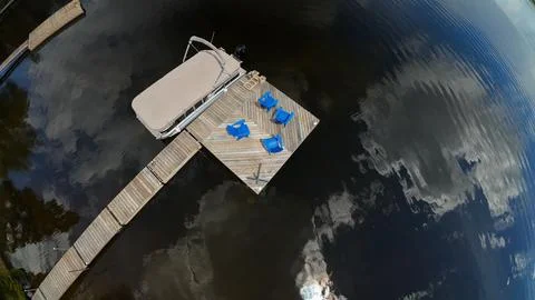 High angle overhead drone view of a covered pontoon boat parked at a dock Foto stock