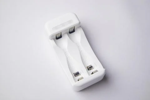 High-angle, overhead shot of an empty white universal battery charger with .. Stock Photos