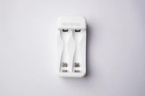 High-angle, overhead shot of an empty white universal battery charger with .. Stock Photos