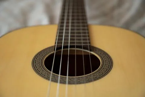 High angle overhead view of acoustic guitar on textured textile. Stock Photos