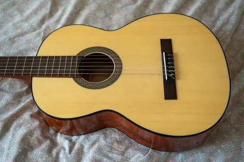 High angle overhead view of acoustic guitar on textured textile. Stock Photos
