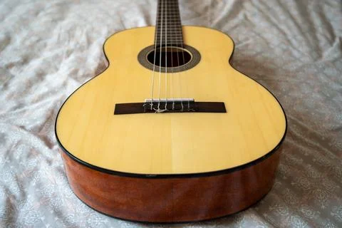 High angle overhead view of acoustic guitar on textured textile. Stock Photos