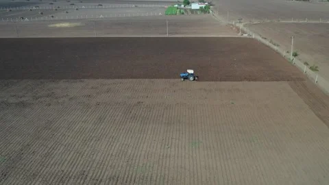 High angle overhead viewpoint tracking a blue farming vehicle as it rows across Stock Footage 337199079