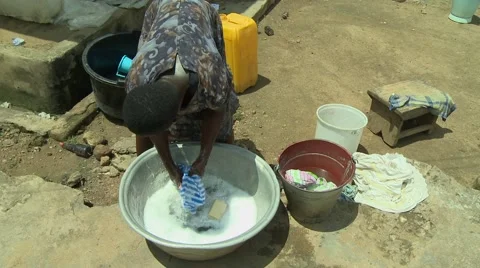 HIGH ANGLE: PAKRO GIRL WASHES CLOTHES Stock Footage 58930195