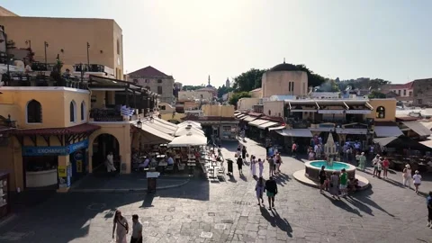 High angle pan right of busy Hippocrates Square in Old Town Rhodes Vidéo 340575908