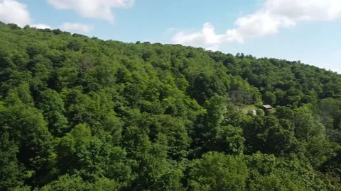 A High Angle Panning Shot That Ends with an Extremely Long Shot of a Rural House Stock Footage