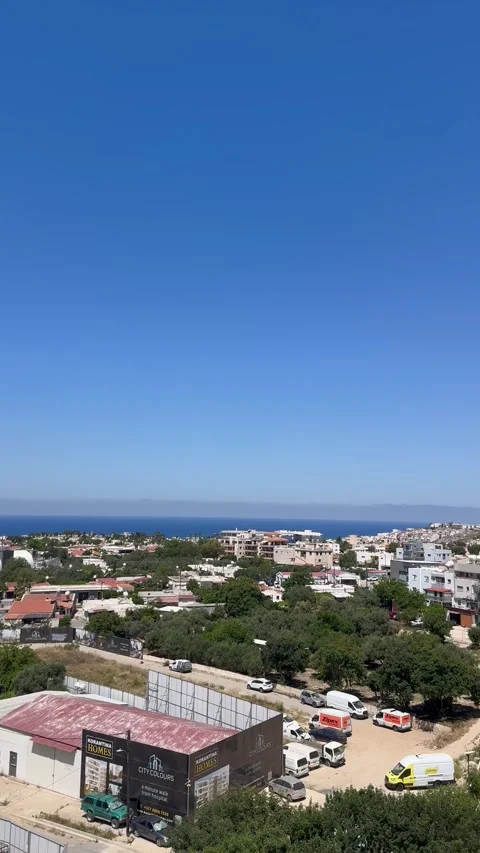 High angle panning shot looking down at the coastal city landscape and sea Stock Footage 336278468