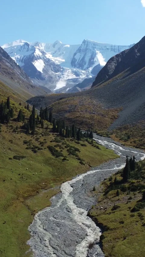 High angle panoramic view of glacial river valley under majestic mountains Stock Footage 336689334