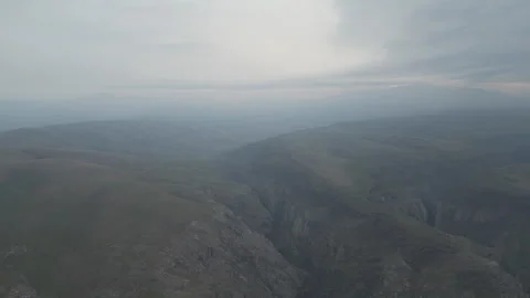 A high-angle perspective of deep shadows and mist settled in a vast canyon. Stock Footage 331165251