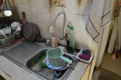High Angle Perspective of Dirty Kitchenware Under Flexible Faucet Stockfoto's