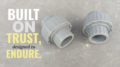 A high angle perspective displays two grey plastic union pipe fittings set .. Stock Photos