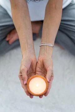 High angle perspective showcasing a lit candle held in peaceful hands Stock Photos