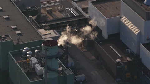 High angle perspective showing steam and smoke rising from a chimney stack on Stock Footage 332204760